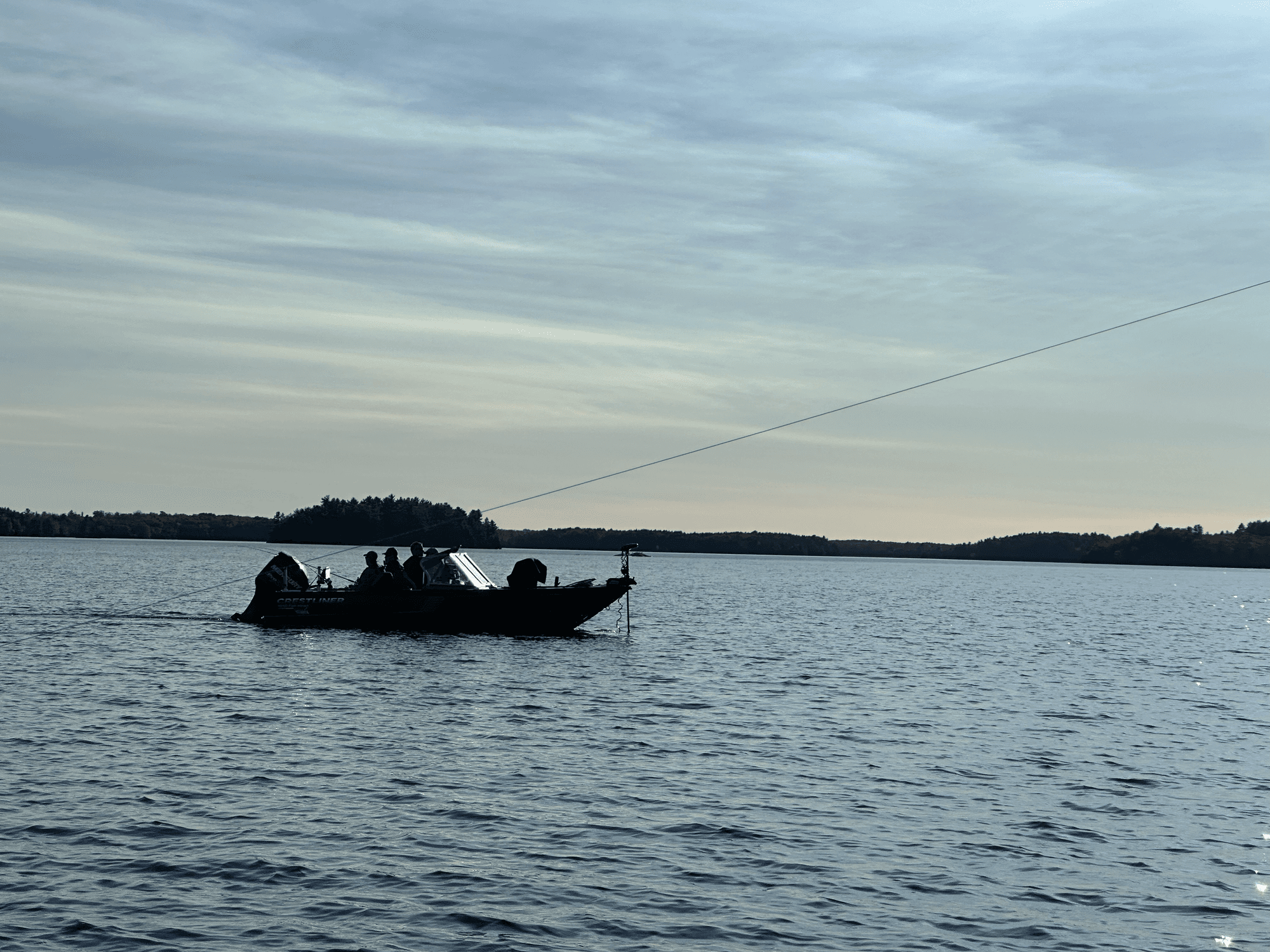 Fishing boat on Big Gull Lake at dusk with calm water reflections